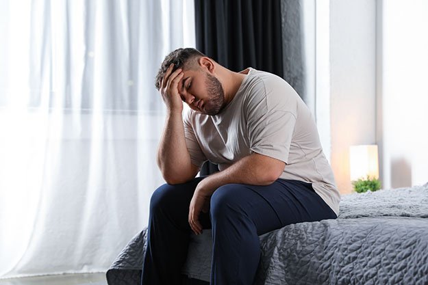 Depressed-man-on-bed-at-home-Causes-of-Estrogen-Dominance-ss-body | Causes & Symptoms Of Estrogen Dominance In Men