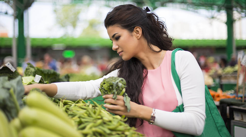 Pretty young woman buying vegetables on the market… of Diindolylmethane (DIM) Supplements | feature | 5 Key Health Benefits of Diindolylmethane (DIM) Supplements