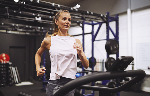 Fit-mature-woman-in-sportswear-smiling-while-working-out-on-a-running-machine-at-the-gym---Recent-Findings-in-Omega-3-Fatty-Acids---ss-body
