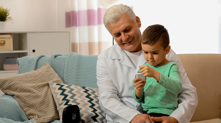 Senior and little kid with digital glucose meter at home - Understanding-the-Hallmarks-of-Aging