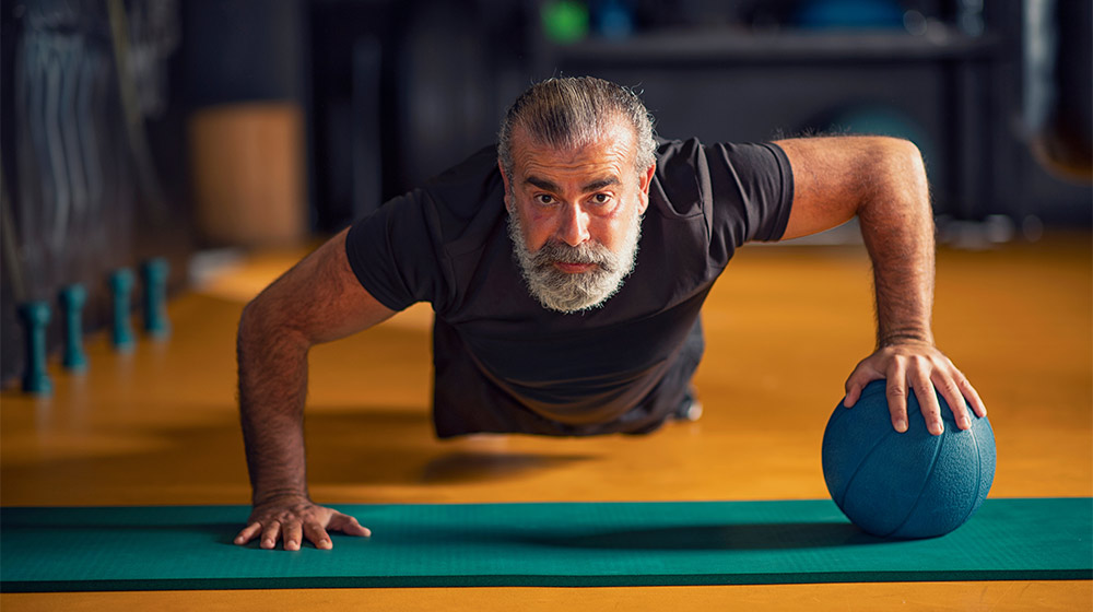 Strong-and-healthy-middle-aged-man-doing-push-ups-with-a-ball---How-Healthy-Muscles-Can-Become-the-Foundation-of-Longevity---as-feat