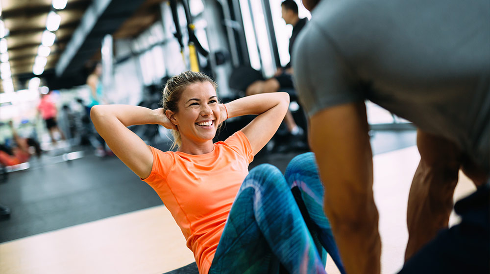 Young-beautiful-woman-doing-exercises-with-personal-trainer---Benefits-of-High-intensity-Interval-Training-May-Include-Improved-COPD---as-feat