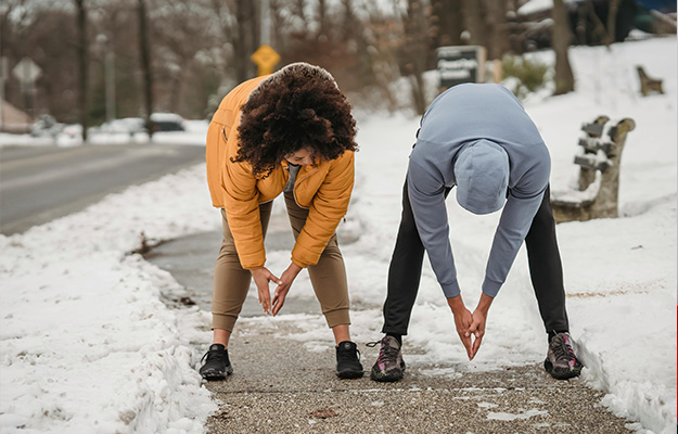 Unrecognizable-ethnic-sportspeople-bending-forward-on-snowy-sidewalk-How-Long-Does-It-Take-To-Lower-Blood-Sugar-With-Diet-And-Exercise-px-body